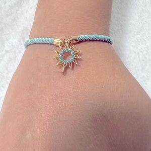 Beautiful light blue (Aqua) rope bracelet w/Gold tone Charm☀️Sun w/blue stones.